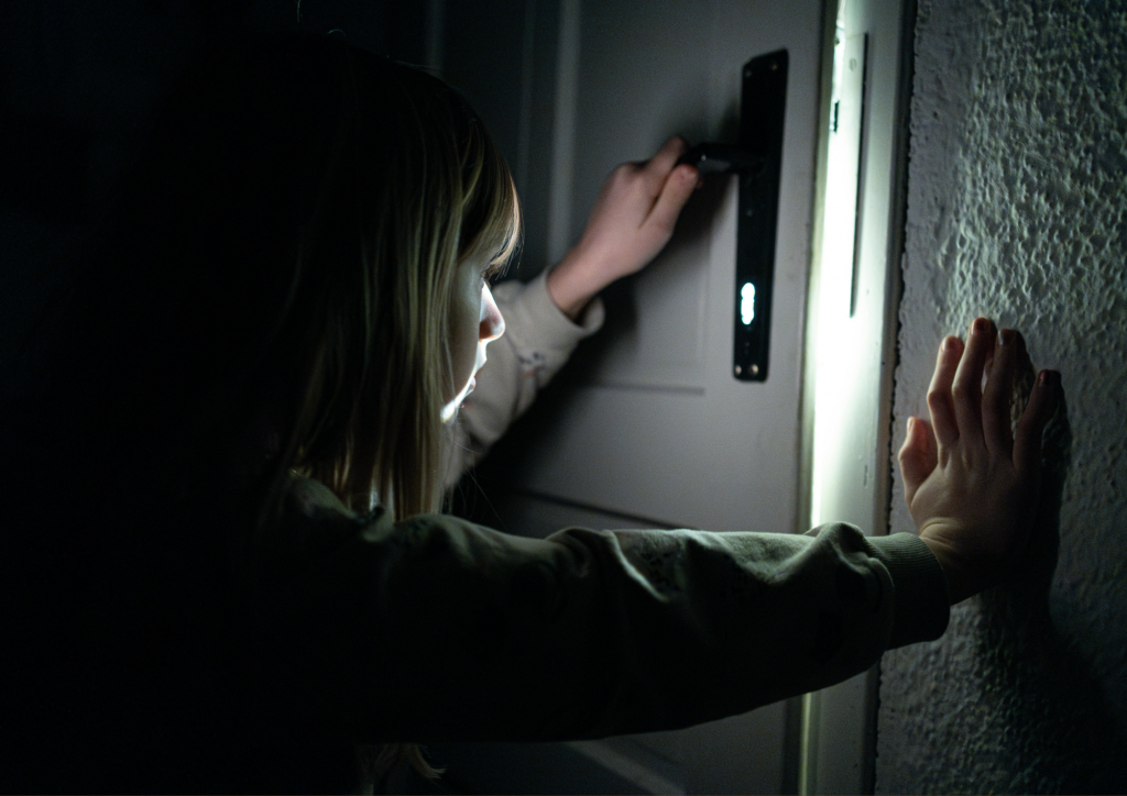 Kind steht zögernd vor einer Tür – Symbolbild für das Tabuthema Psychotherapie und die Hemmschwelle, Hilfe anzunehmen